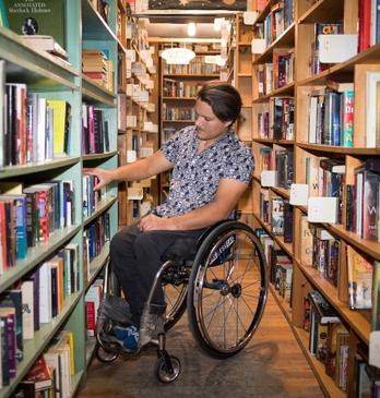 Man in Wheelchair exploring bookshelf