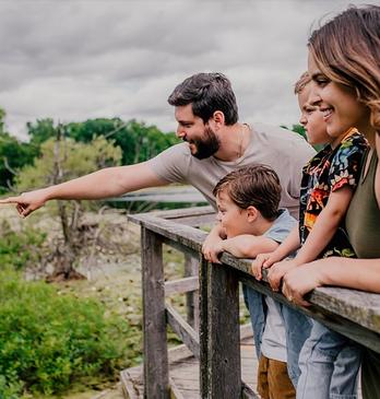 A family standing at a dock overlooking Westminster Ponds located in London, Ontario