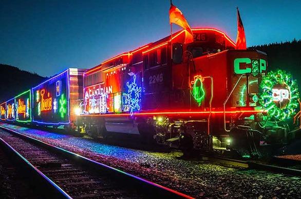 A brightly coloured train decorated for the holidays and lit with neon lights