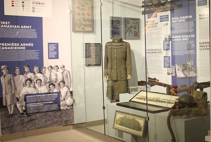 Canadian Armed Forces exhibit with text panels, military uniforms, and artifacts, highlighting roles of women.