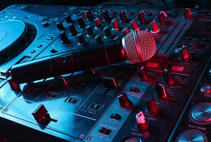 A microphone resting on a DJ mixing console