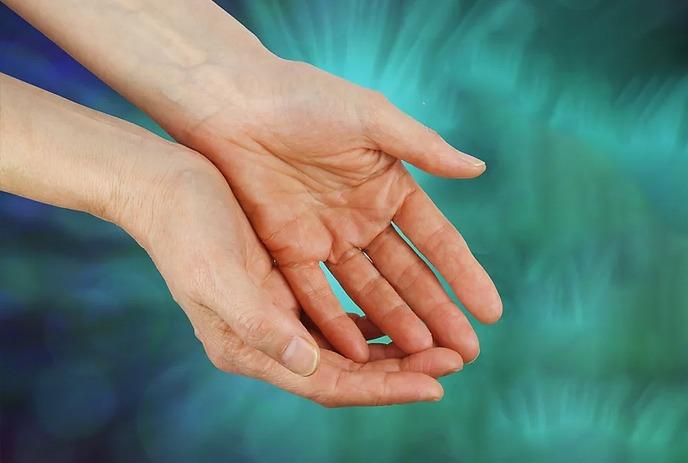 Two open hands against a radiant teal backdrop, suggesting care or offering.