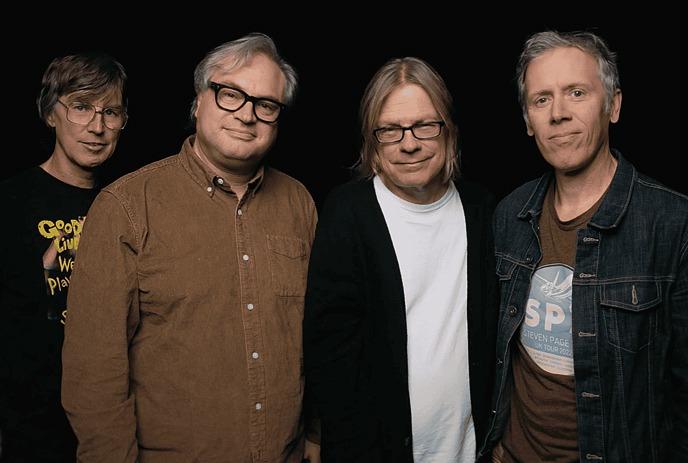 The 4 band members of the Trans-Canada Highwaymen, standing in front of a black background.