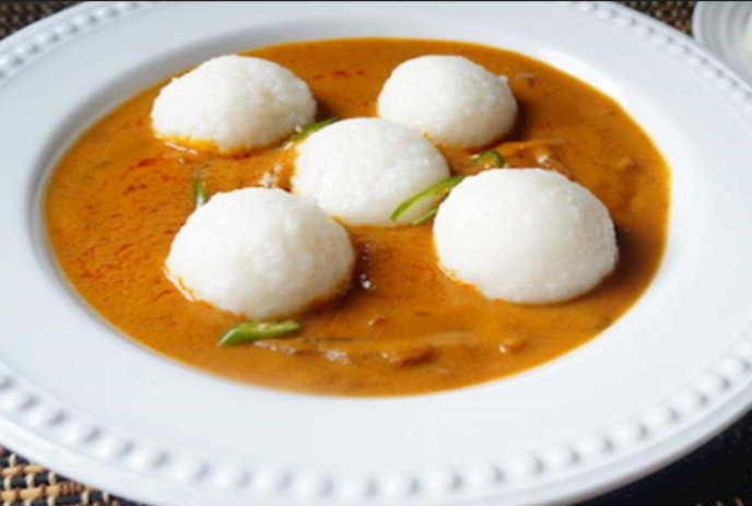 Bowl of soup with dumplings and vegetables in it.