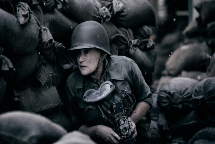 Person in combat clothing holding a camera in a bunker.