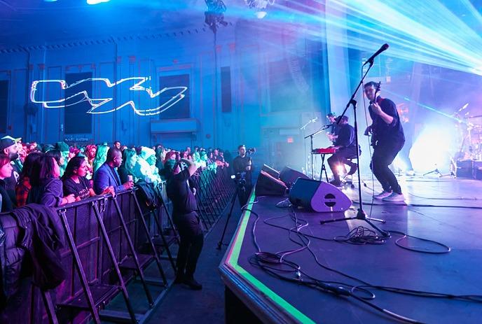 Wing Night: The Band performing on a brightly lit stage in front of a large, energetic crowd.