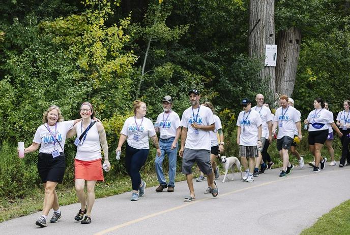 Group of people walking outdoors for the “20th Annual Walk for Wellspring” event, supporting a cancer support center.