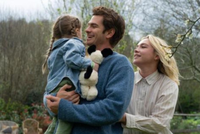 Two parents and a child walking through the woods looking happy.