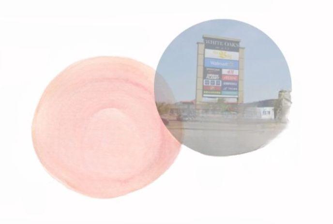 A light pink circle overlaps with a transparent circle containing a shopping center sign for 'WHITE OAKS