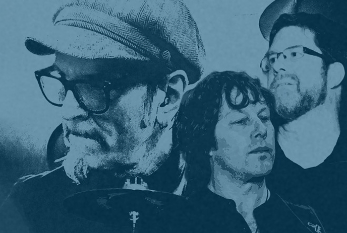 The image shows a blue-toned, stylized photo of three musicians, each with unique expressions.