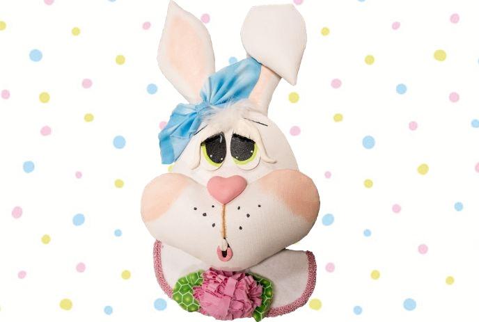 A plush bunny decoration with a blue bow and rosy cheeks in front of a polka dot background.