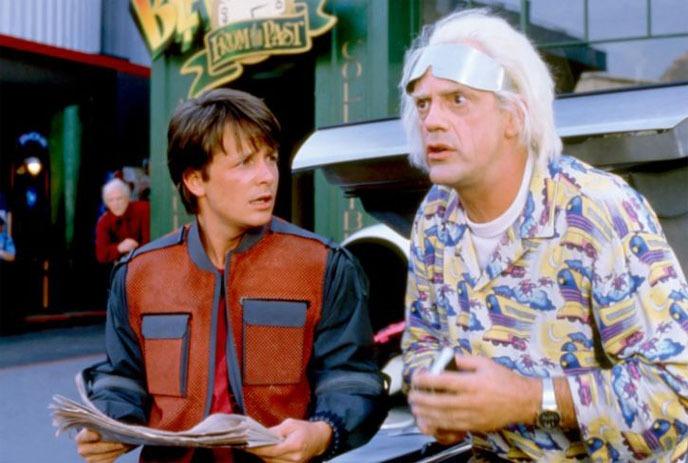 Two characters from “Back to the Future Part II” in front of a building labeled “Cafe 80’s.