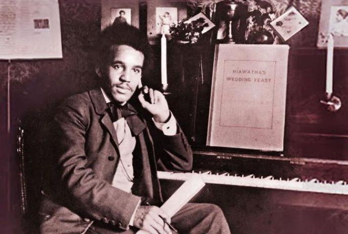 Sepia image of a person sitting in front of a piano.