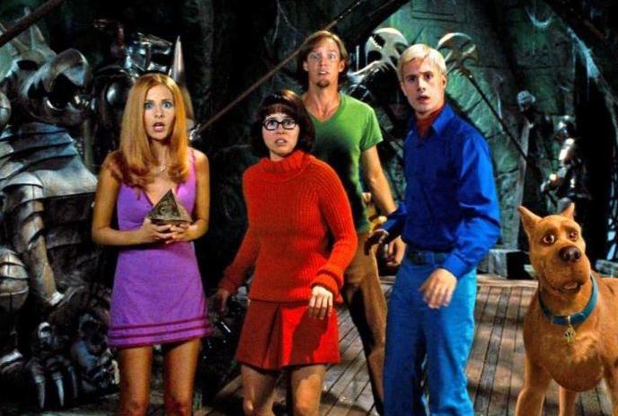 5 Characters in a movie scene from Scooby Doo in their colorful costumes.