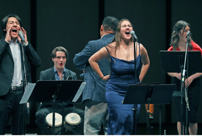 A group of 5 musicians on the stage performing during an event.