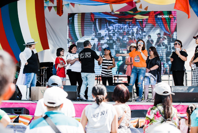 A lively group of people performing on stage at a previous Fiesta Extravaganza event.