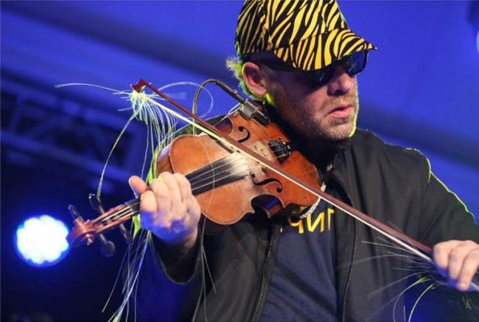 Ashley Macisaac playing the fiddle on stage.