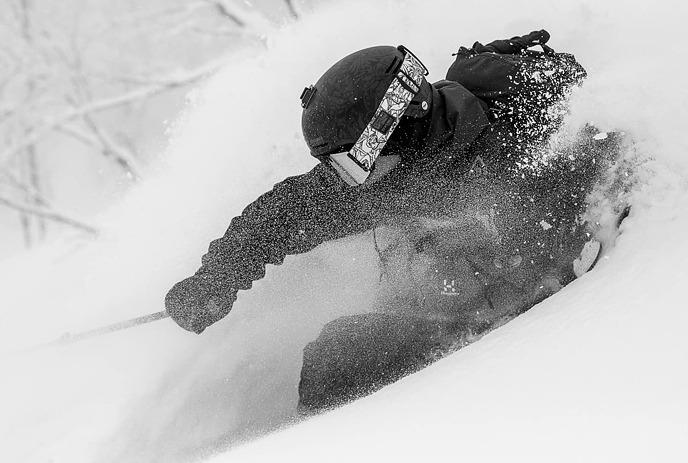 Person wearing ski gear, going down a mountain.