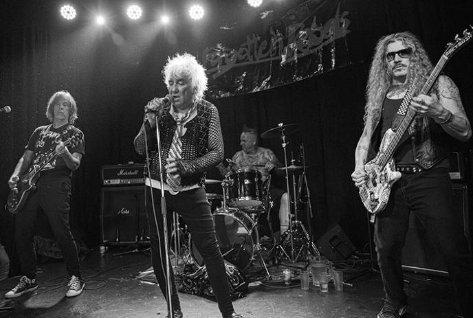 A black and white photo of Forgotten Rebels performing on stage.