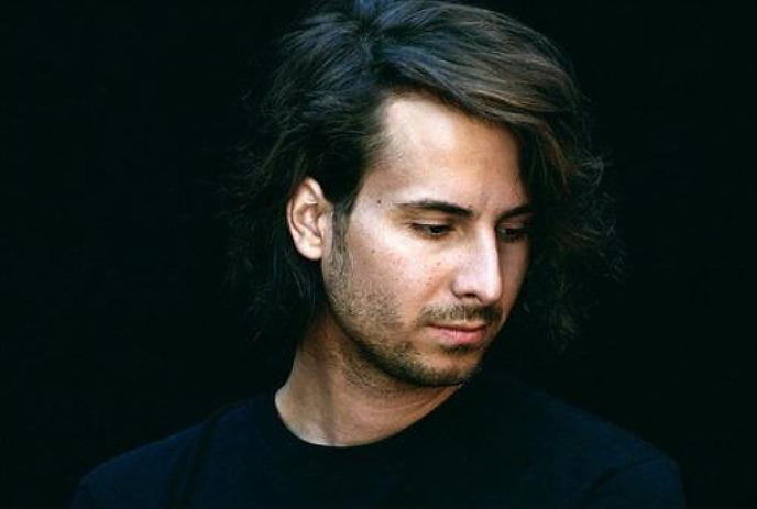 A headshot of Bobby Bazini, looking downwards against a black background.