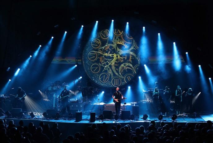 Brit Floyd performing on stage under a dark blue and black stage and spotlights.