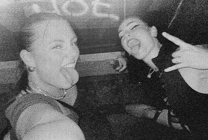 2 women artists taking a selfie with their tongues out and posing in an black and white frame.