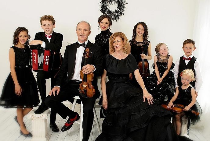 Natalie Macmaster, Donnell Leahy and 7 others posing in a white room wearing formal attire.