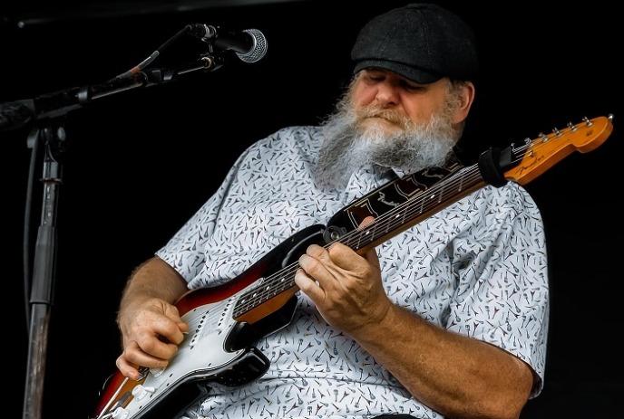 Big Dan Jeffares playing his guitar on stage.