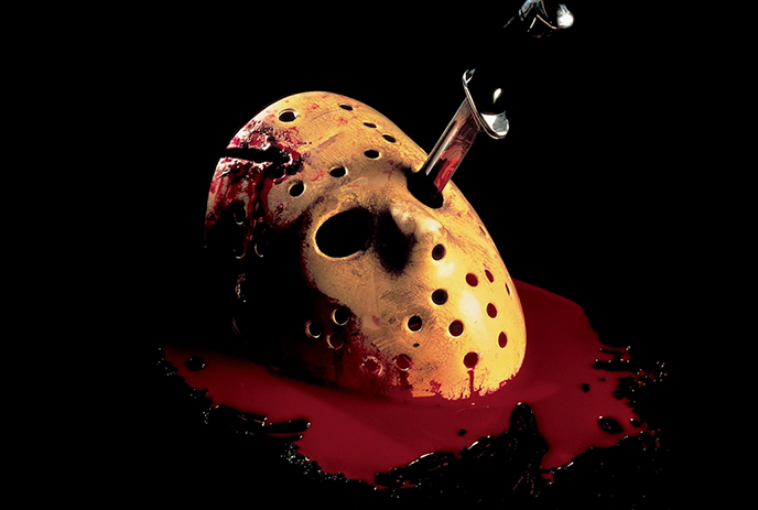 Hockey mask with blood stains on it, pierced by a knife, lying in a pool of blood against a dark background.