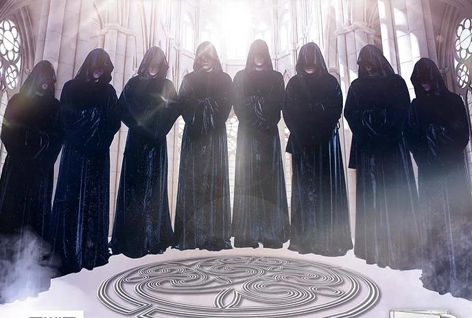 A group of hooded figures in black robes stand in a misty, gothic setting.