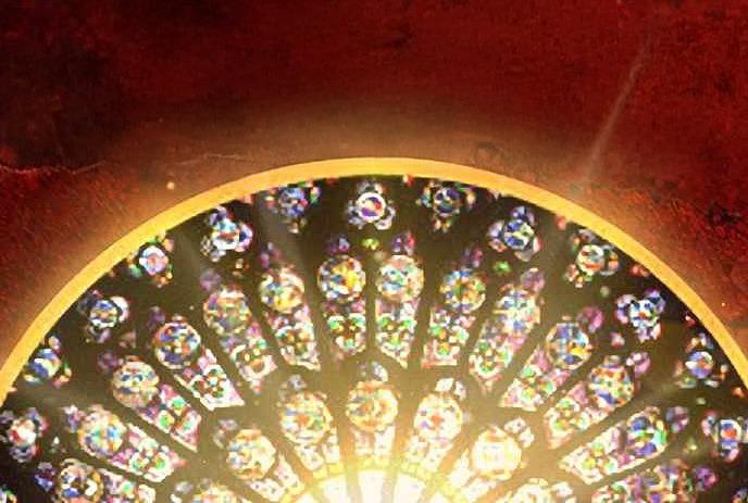 A vibrant, circular stained-glass window with intricate patterns and colors, illuminated against a dark red background.