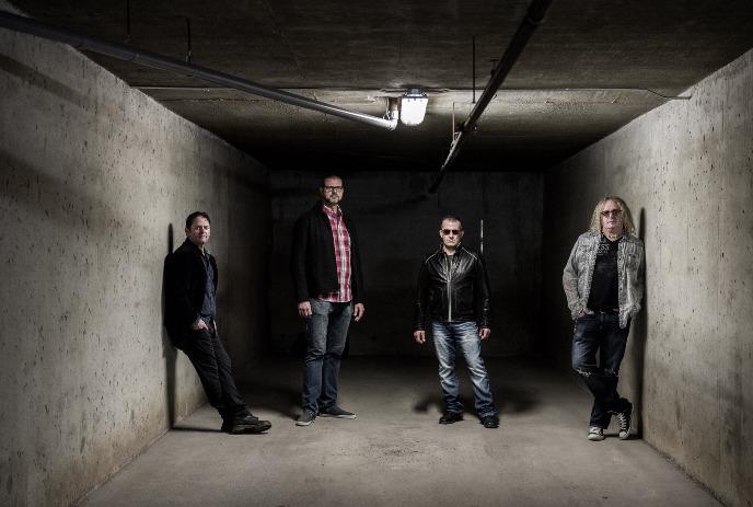 The 4 band members of Brother Leeds, standing in a room made of cement.