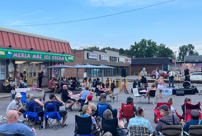 Outdoor concert at Merla Mae Ice Cream with a crowd enjoying live music.