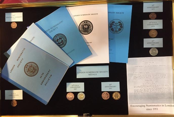 A collection of blue and black coin cases from the London Numismatic Society.