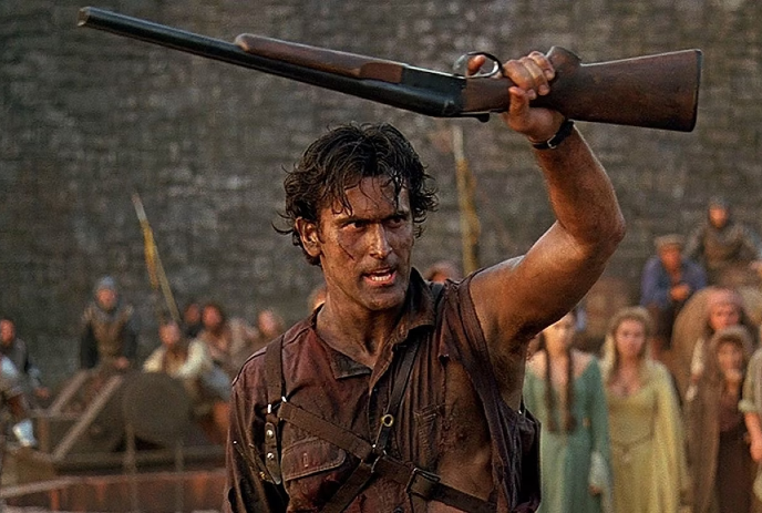 A rugged man with messy hair and a torn shirt holds a shotgun in the air, surrounded by medieval villagers.