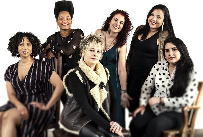 Jane Bunnett with Maqueque, a group of six women posed together against a white background.