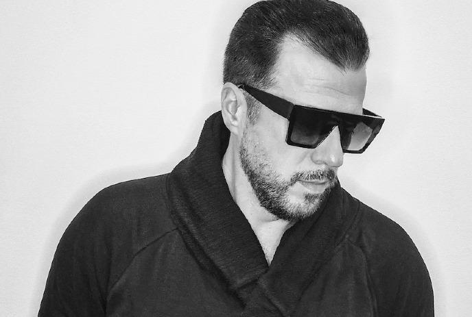 A black and white closeup photo of Jay Lumen wearing sunglasses.