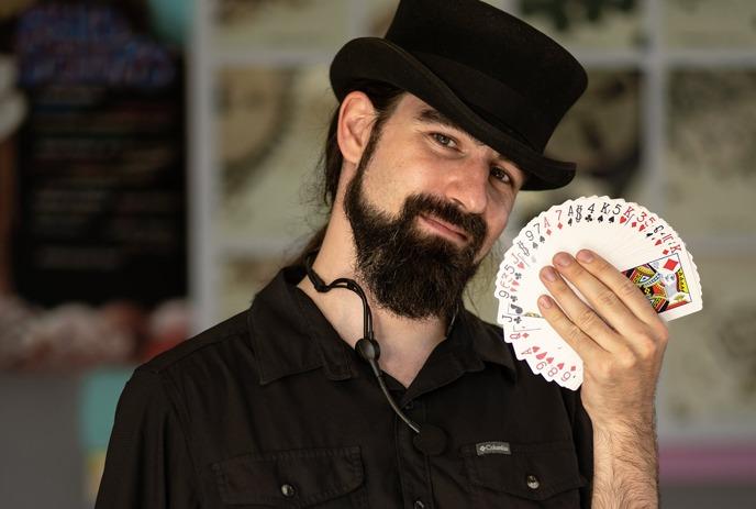 Magician Spencer Scurr holding a set of cards in his hands