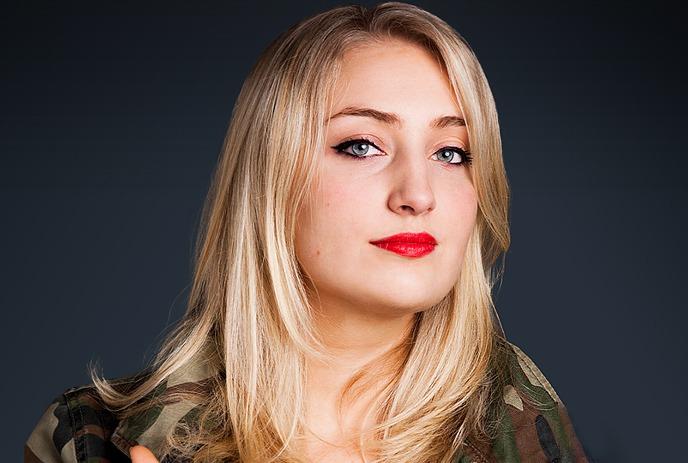 Sophie Buddle wearing a camo jacket, looking at the camera.