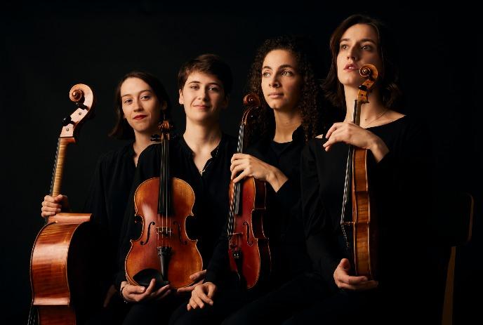 Four performing artists, each holding a string instrument: cello, two violins, and viola under a dark background.