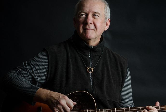 Musician Murray McLauchlan holding a guitar