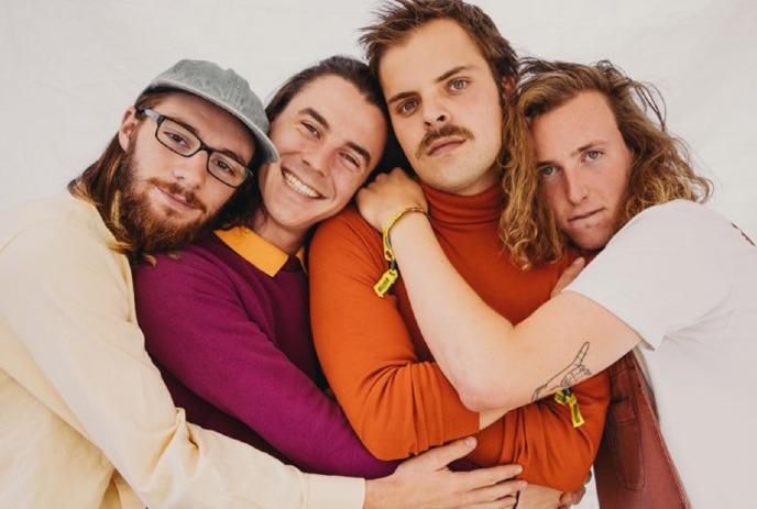 The 4 band members of Peach Pit hugging each other, against a white background.