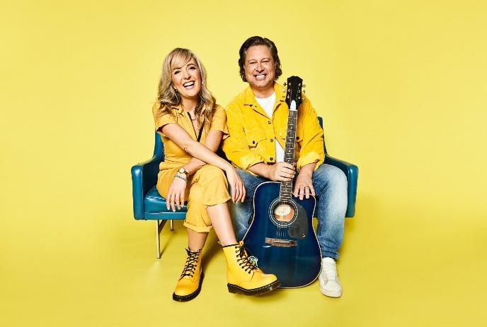 Nick Adams and Taes Leavitt of Splash'N Boots sitting down, posing for the camera in front of a yellow background.