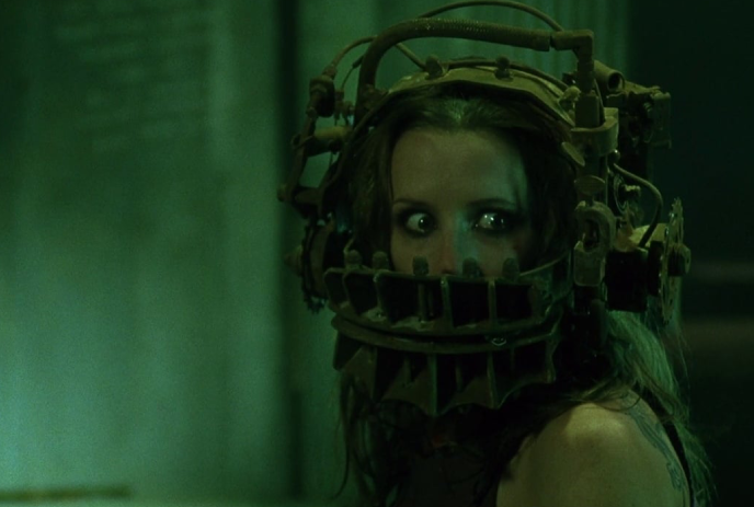 A woman wearing a complex headgear with metal components and gears, creating a mysterious and eerie atmosphere.