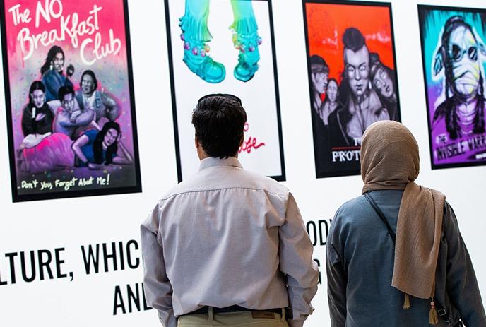 Collection of colorful movie posters on a wall, featuring various titles and designs.