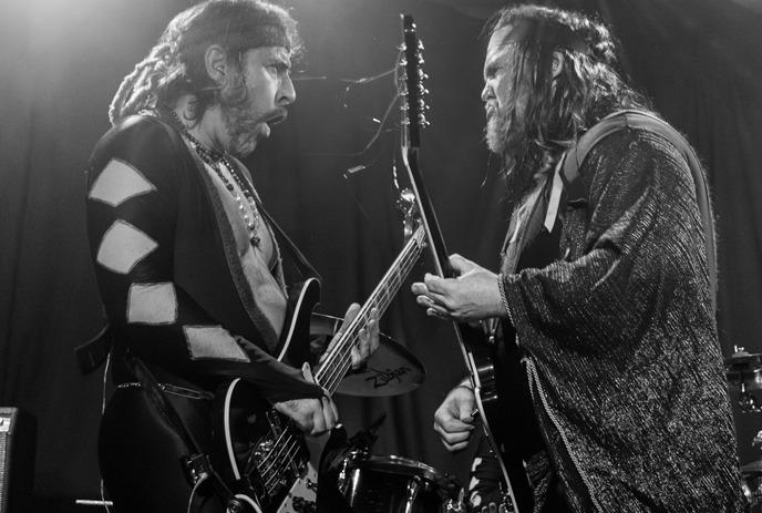 Members of the band Sons of Butcher, playing an electric guitars on a stage