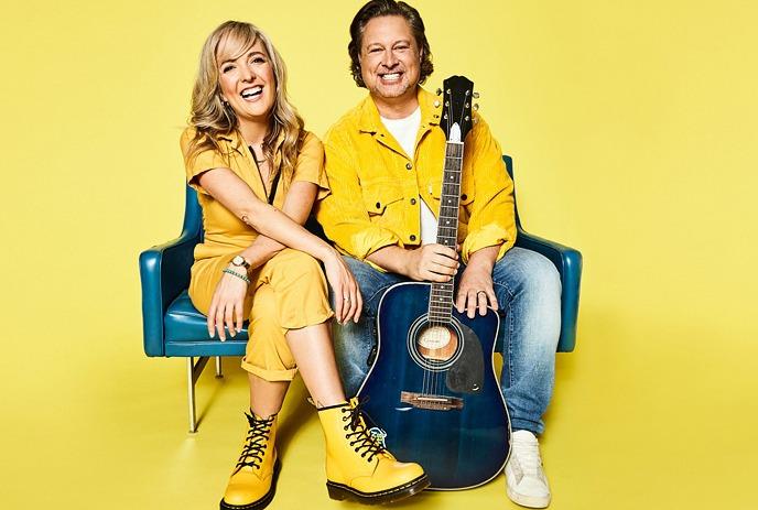 Nick Adams and Taes Leavitt of Splash'N Boots sitting down, posing for the camera in front of a yellow background.