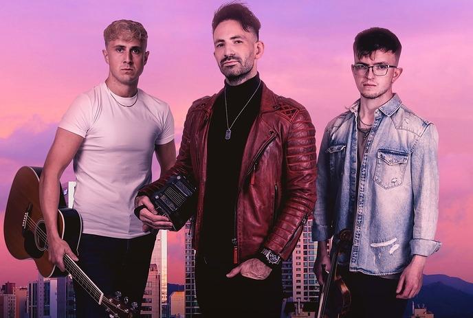 Three men musicians holding instruments against a cityscape at dusk with pink and purple sky.