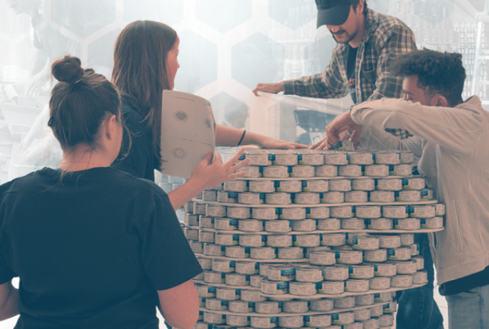 Four people participating in the building process during a previous Canstruction event.