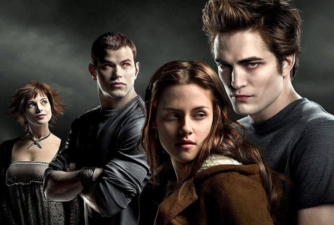 4 cast members of Twilight standing together against a dark, cloudy background.